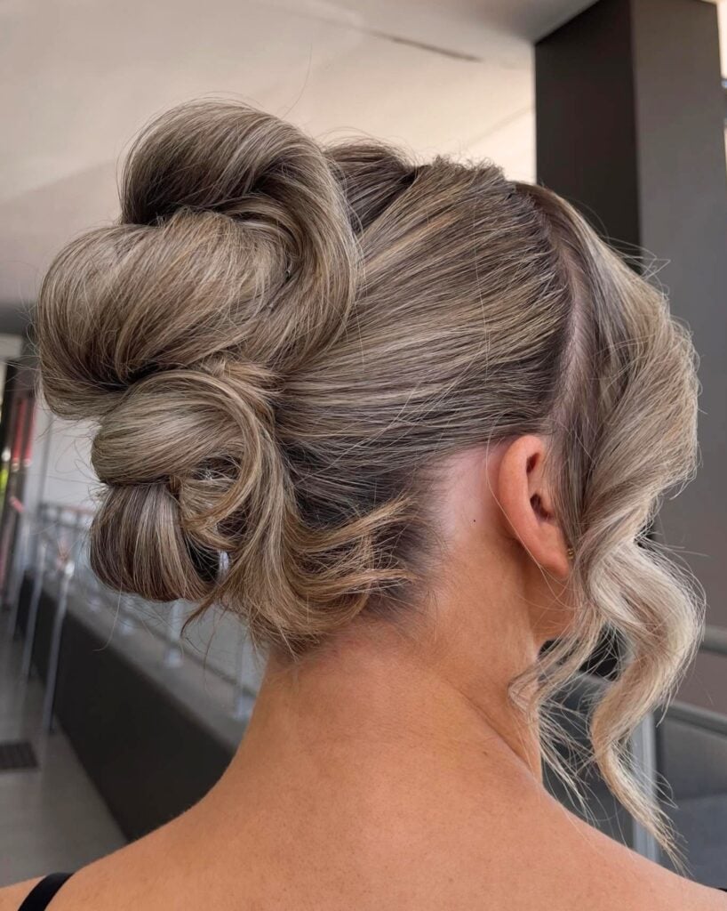 Textured twisted upstyle on blonde hair with face-framing waves, by Circles of Hair Perth