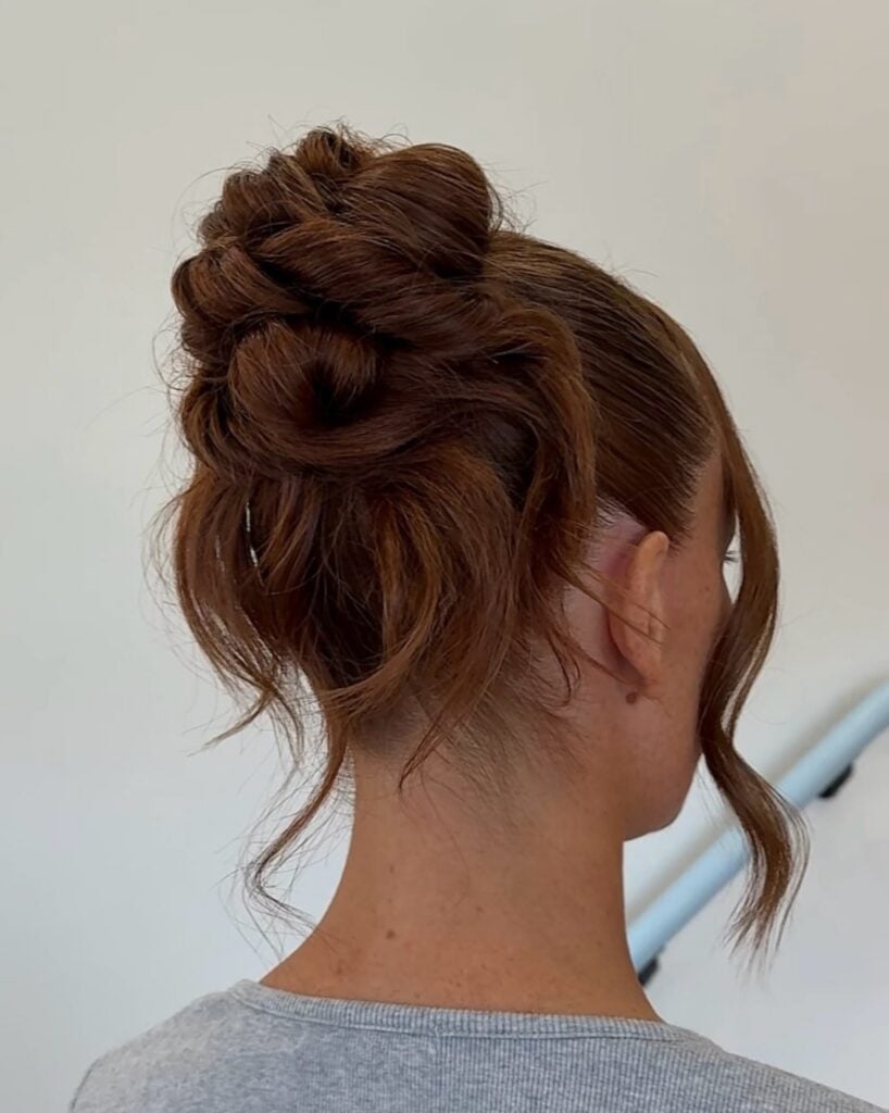 Soft messy copper bun with loose face-framing pieces, by Circles of Hair Perth
